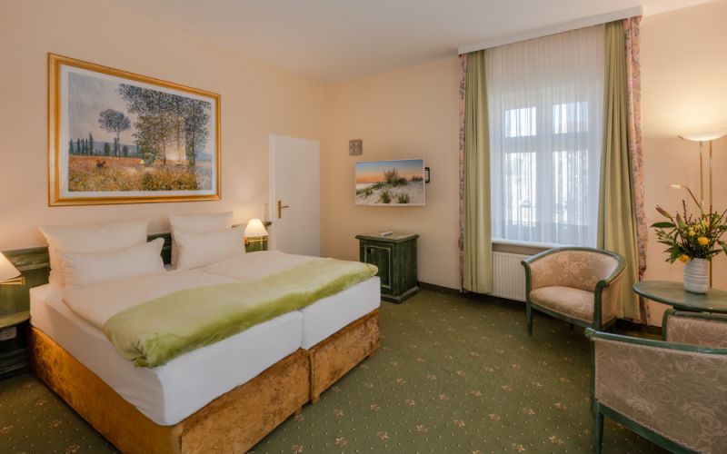 Doppelzimmer Landseite im Chalet Vineta mit Doppelbett und Sitzecke